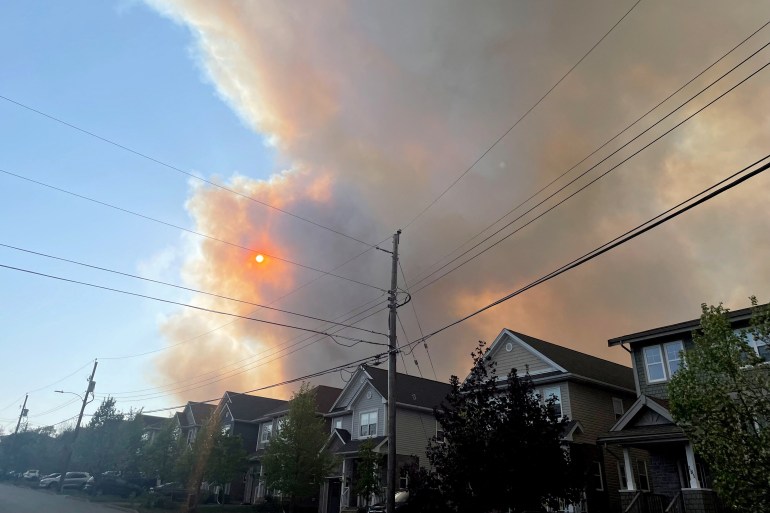Il fumo di un incendio in Nuova Scozia si diffonde sulle case nella vicina Bedford, in Canada