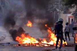 A member of Senegal’s security forces passes a burning barricade in Dakar, Senegal [Zohra Bensemra/Reuters]