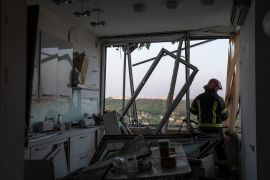 A rescuer works inside an apartment building which was damaged during a massive Russian drone strike