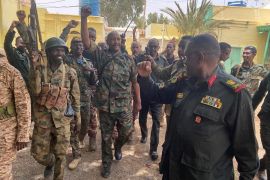 Sudan&#39;s General Abdel Fattah al-Burhan walks with troops in an unknown location [Sudanese Armed Forces via Reuters]