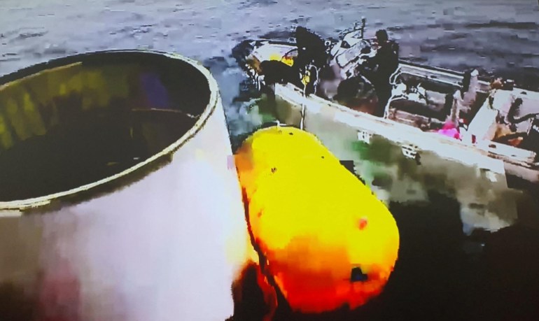 South Korean divers salvaging what is suspected to be the debris from the North Korean launch