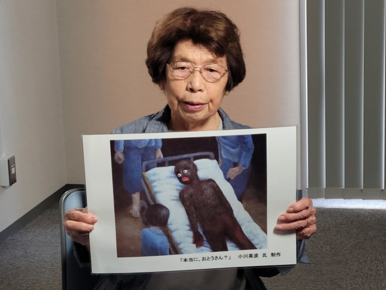 A woman holds a drawing based on someone injured in the Hiroshima bombing