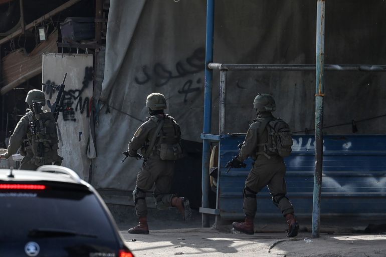 Israeli troops take position in the Nur Shams Palestinian refugee camp near in the northern West Bank town of Tulkarem on April 10,2022, during a raid looking for suspects related to a gunman from Jenin who went on a shooting rampage in a popular Tel Aviv nightlife area on April 7, killing three Israelis and wounding more than a dozen others. (Photo by JAAFAR ASHTIYEH / AFP)