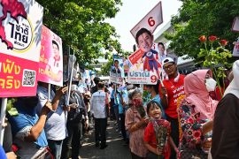 Supporters of various political parties in Thailand gather with placards as candidates register to vote