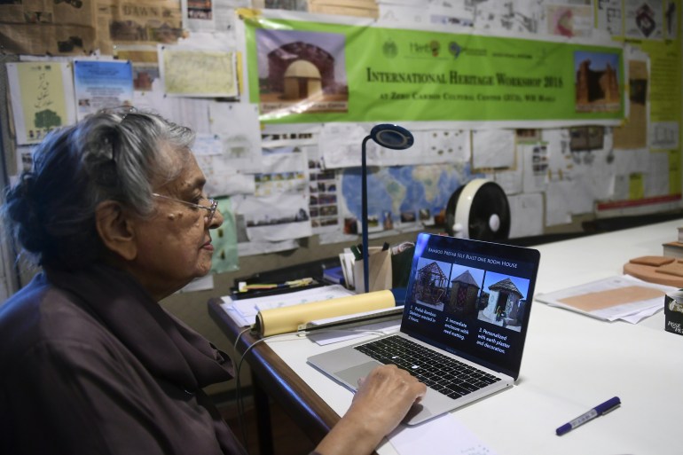 In this picture taken on April 10, 2023, architect Yasmeen Lari, the head of Heritage Foundation of Pakistan, shows pictures of huts on a laptop at her office in Karachi.