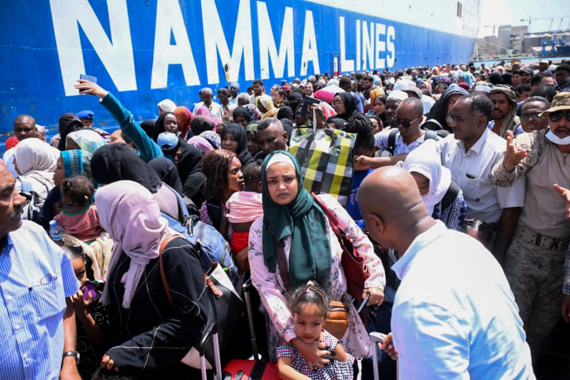 People fleeing war-torn Sudan queue to board a boat from Port Sudan