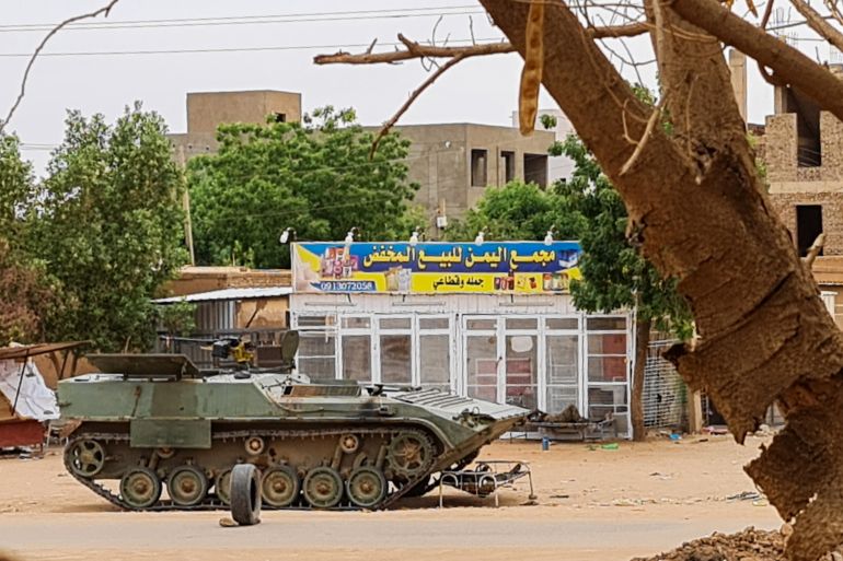 Soldati dell'esercito sudanese che riposano vicino a un carro armato a un posto di blocco a Khartoum.  Sudan.