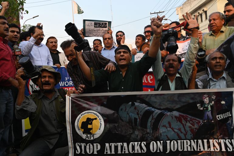 Pakistani photojournalists hold their cameras and shout slogans during a demonstration to mark World Press Freedom Day in Lahore on May 3, 2023