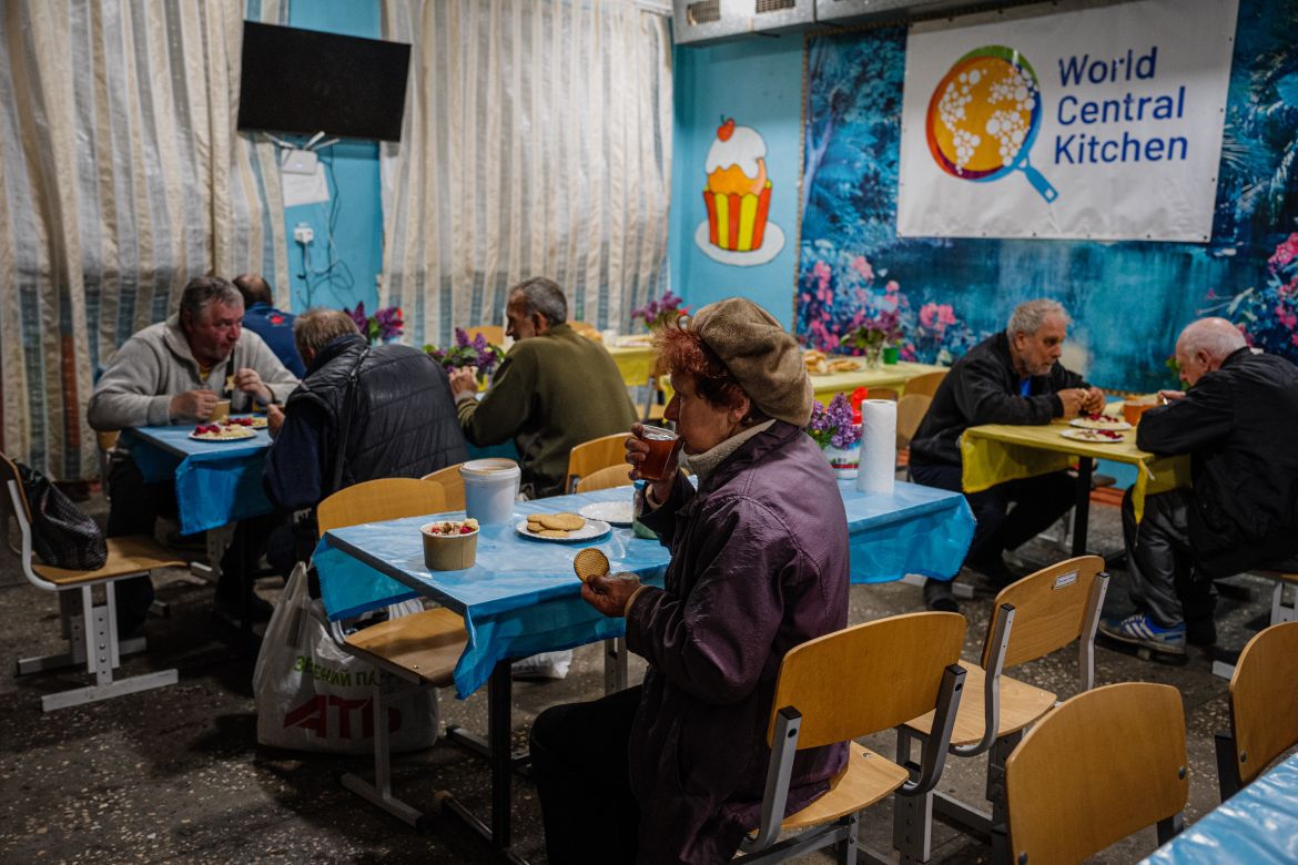 Local residents sit in a volunteer run shelter, providing access to laundry and bathroom facilities where they can warm up, charge their phones, drink hot tea and receive humanitarian aid in the town of Orikhiv, in the Zaporizhzhia region