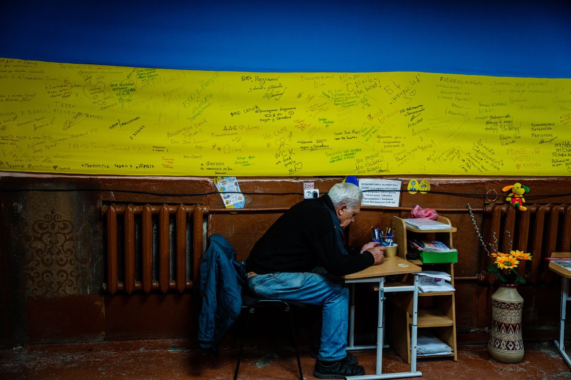 Local residents sit in a volunteer run shelter, providing access to laundry and bathroom facilities where they can warm up, charge their phones, drink hot tea and receive humanitarian aid in the town of Orikhiv, in the Zaporizhzhia region
