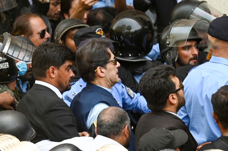 Policemen escort Pakistan's former Prime Minister Imran Khan (C) as he arrives at the high court in Islamabad on May 12, 2023.