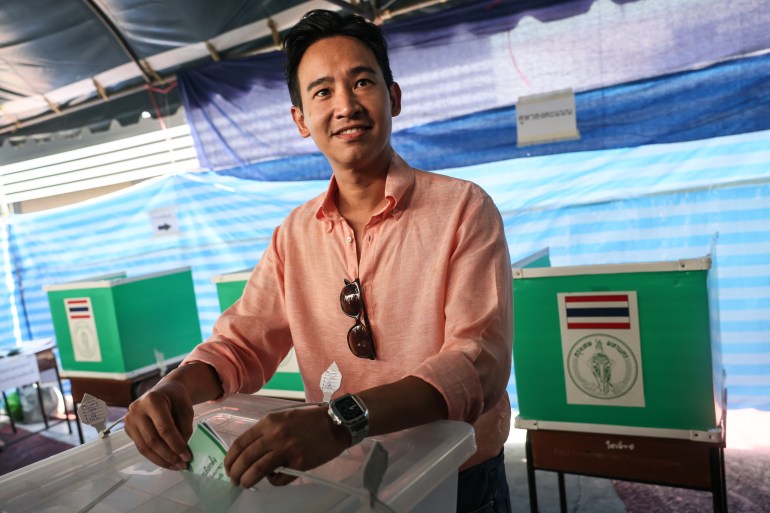 Move Forward Party leader and prime ministerial candidate Pita Limjaroenrat casts his ballot at a polling station. He is smiling.