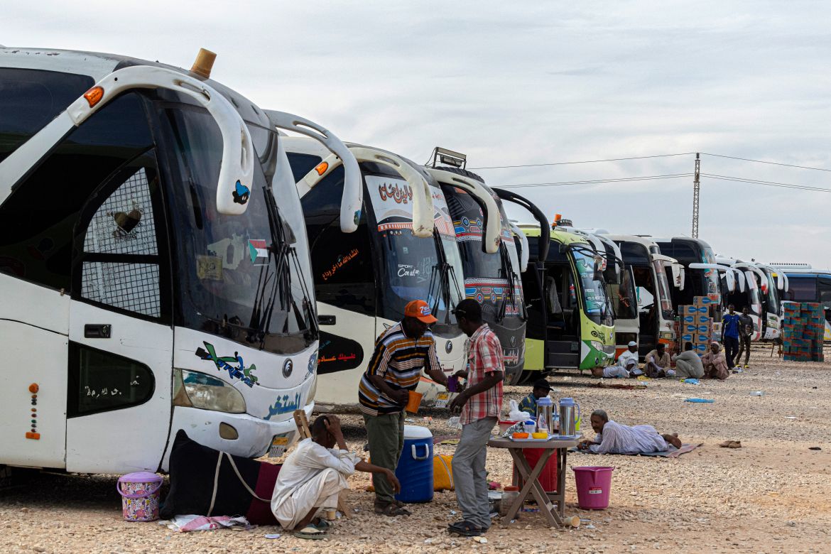 Sudanese drivers rest by their buses after transporting evacuees from Sudan into Egypt, in Wadi Karkar village near Aswan