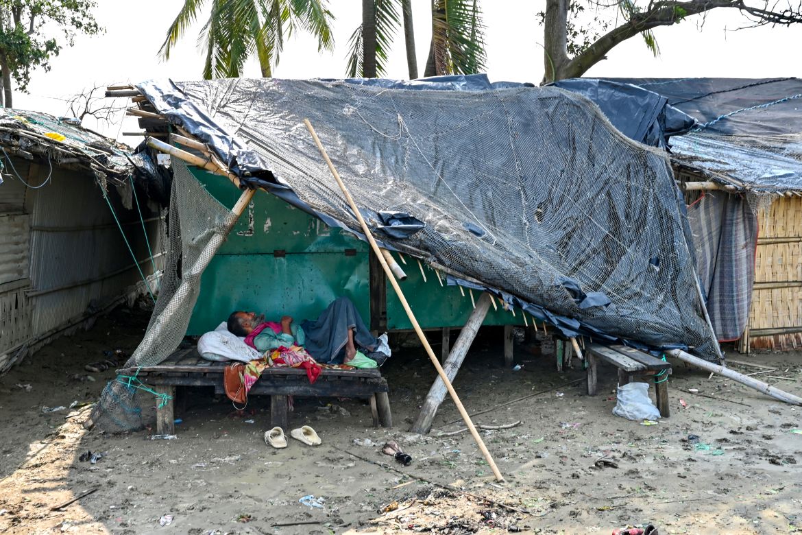 A man rests at a house which was partially destroyed by cyclone Mocha, in Shahpori island on the outskirts of Teknaf