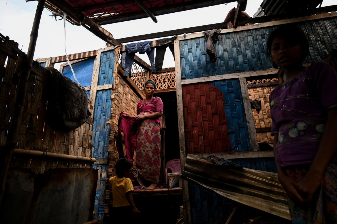 A Rohingya woman stands in her damaged house at Basara refugee camp in Sittwe