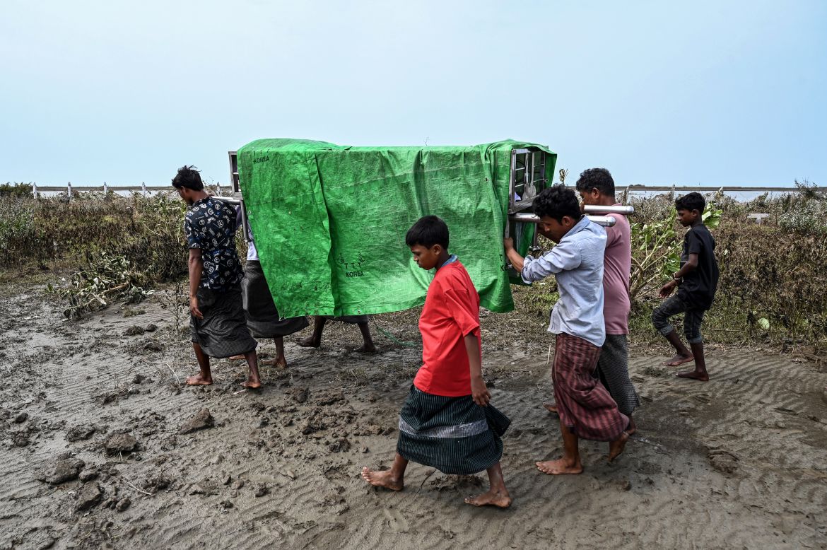 People carry the body of a victim during a funeral near Basara refugee camp in Sittwe