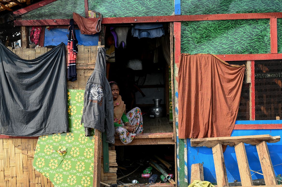 A Rohingya woman sits in her destroyed house at Ohn Taw Chay refugee camp in Sittwe
