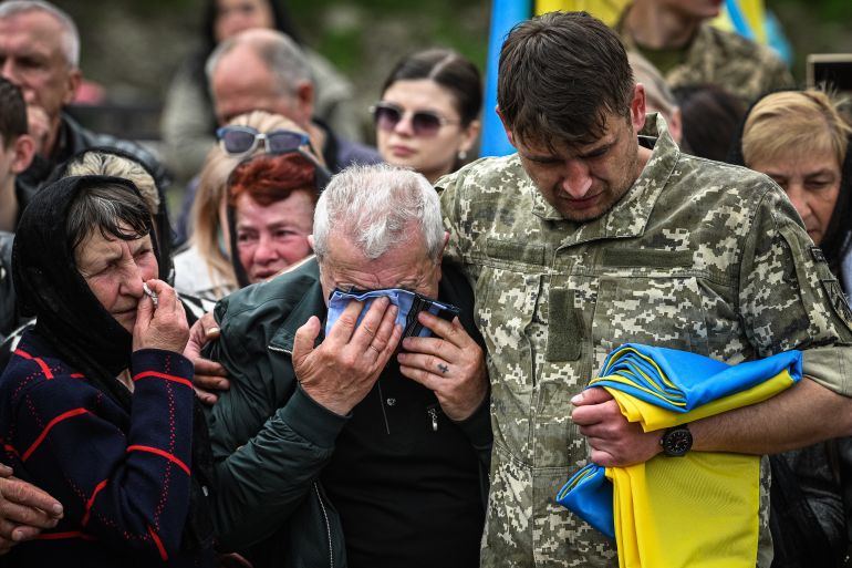 Parentes e amigos do soldado ucraniano morto em combate com as tropas russas lamentam a invasão russa da Ucrânia. [Yuriy Dyachyshyn/AFP]
