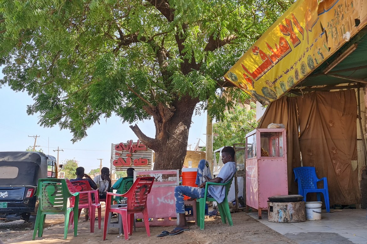 People rest under a tree in a roadside coffee shop in southern Khartoum