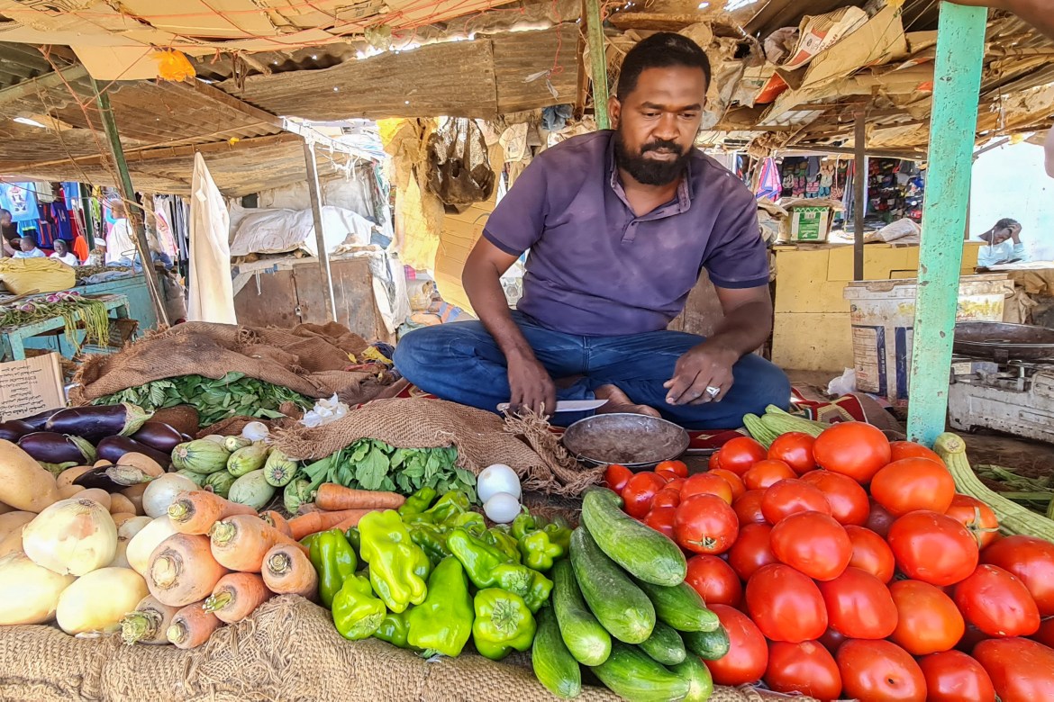 A vendor sells fresh produce at a market in southern Khartoum