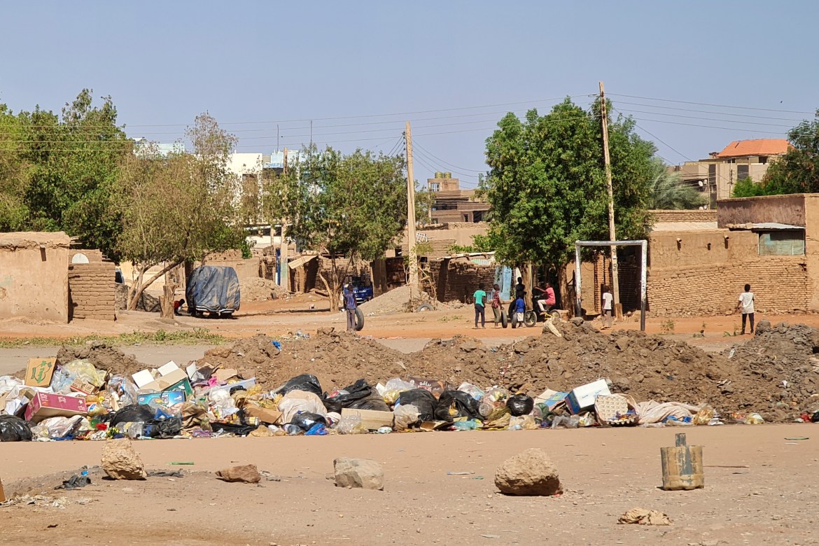 Youths play outdoors near a blocked road in southern Khartoum