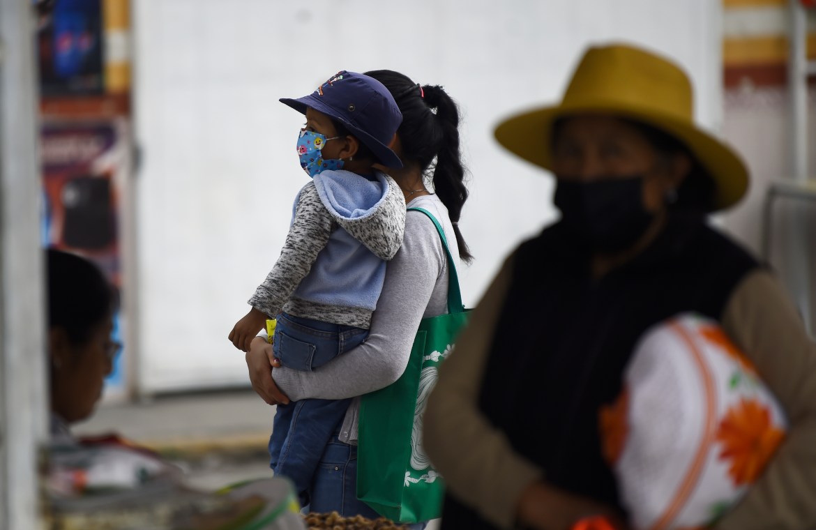 Residents wear protective masks due to the falling ashes from the Popocatepetl volcano, in the village of Santiago Xalitzintla