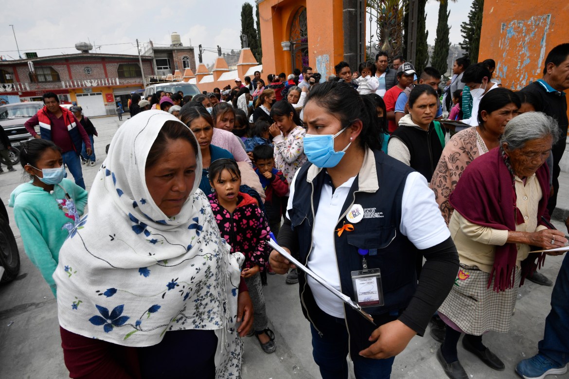 Residents line up to receive a protection kit in case of ash fall in the village of Santiago Xalitzintla