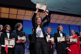 French director Justine Triet celebrates on stage after winning the Palme d&#39;Or during the closing ceremony of the Cannes Film Festival in Cannes, southern France [Valery Hache/AFP]