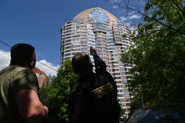 A security guard points at a multi-storey apartment building after a reported drone attack in Moscow [Kirill Kudryavtsev/AFP]