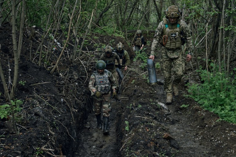 Soldados ucranianos caminham em uma trincheira perto de Bakhmut, uma cidade do leste onde ocorrem ferozes batalhas contra as forças russas, na região de Donetsk, Ucrânia, sábado