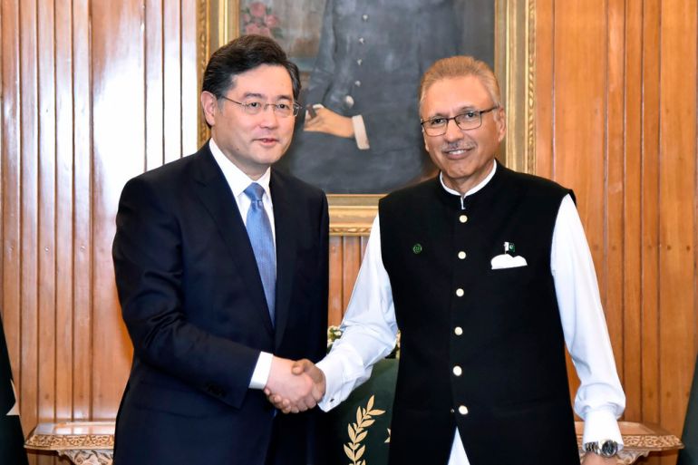 In this photo released by Pakistan's President office, visiting Chinese Foreign Minister Qin Gang, left, shakes hand with Pakistani President Arif Alvi prior to their meeting, in Islamabad, Pakistan, Friday, May 5, 2023. The Pakistani president on Friday assured Beijing's top diplomat that his country will boost security for all Chinese nationals working on multi-billion dollar projects in cash-strapped Pakistan. (Pakistan President Office via AP)