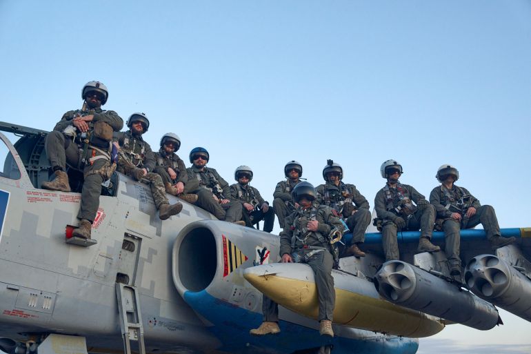 Ukrainian air force pilots pose for a photo as they sit on a Su-25 ground attack jet on their base in Eastern Ukraine, Thursday, May 4, 2023.