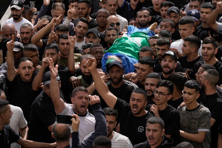 Palestinians carry the body of militant Hamza Kharyoush in the Nur Shams refugee camp near the city of Tulkarem, in the occupied West Bank.