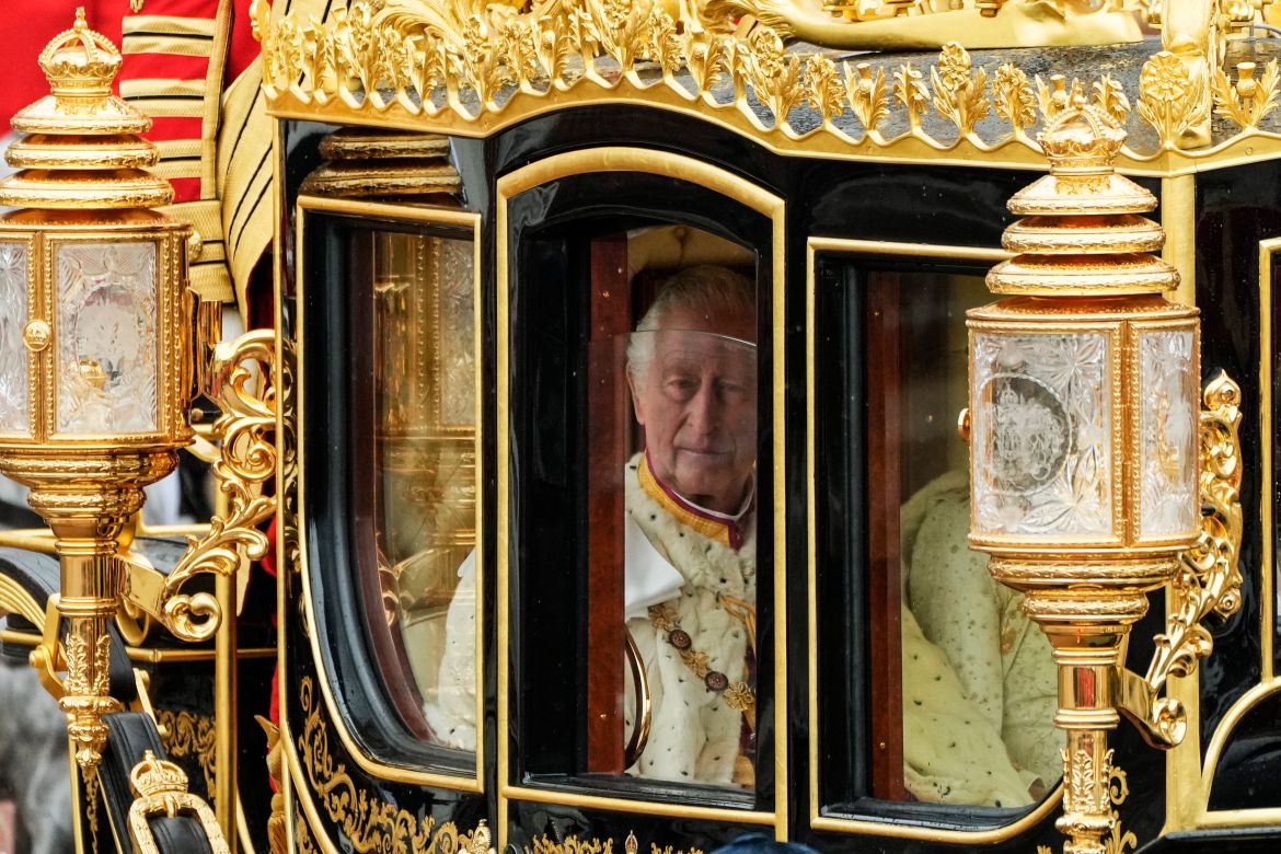 Britain's King Charles III is seen through the window of the Diamond Jubilee State Coach as he leaves Buckingham Palace with Camilla, the queen consort, for the coronation ceremony.
