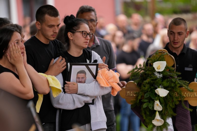 Relatives of victims are pictured at the funeral of five people who died in the second shooting in two days in the village of Maro Olache, about 50 kilometers (30 miles) south of Belgrade, Serbia, Saturday, May 6, 2023. is carrying In Thursday's attack, his 20-year-old gunman opened fire indiscriminately in two of his villages in Serbia, killing eight and wounding 14.  (AP Photo/Darko Vojinovic)