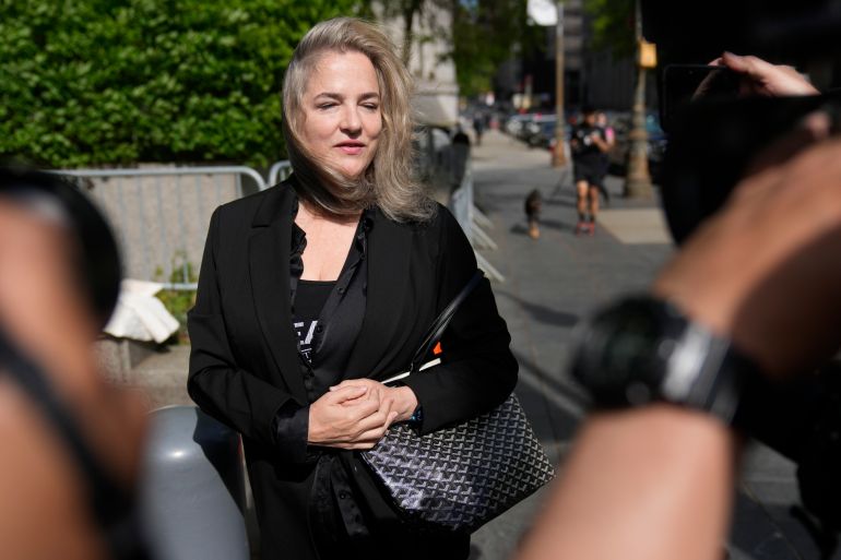 A blonde woman, dressed all in black, is photographed outside of a courthouse