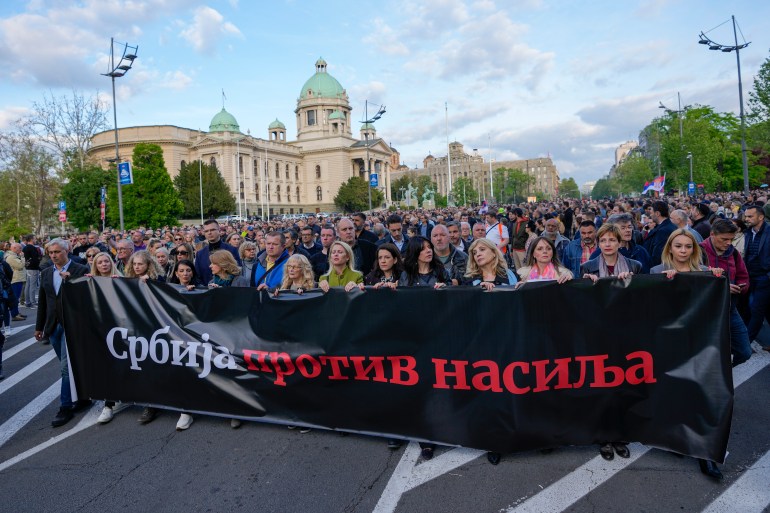 People hold a banner with writing reading: "Serbia against violence" during a march against violence in Belgrade, Serbia, Monday, May 8, 2023. The shootings last Wednesday in Belgrade and a day later in a rural area south of the capital left the nation stunned. The shootings also triggered calls to encourage tolerance and rid society of widespread hate speech and a gun culture stemming from the 1990s wars. (AP Photo/Darko Vojinovic)