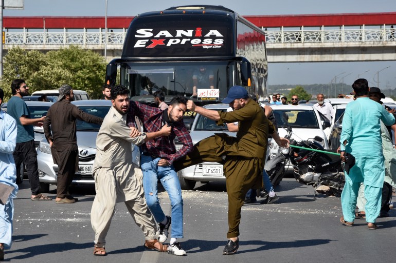 Policiais à paisana espancam um apoiador do ex-primeiro-ministro do Paquistão, Imran Khan, enquanto o detêm quando ele com outros bloqueando uma estrada como protesto para condenar a prisão de seu líder