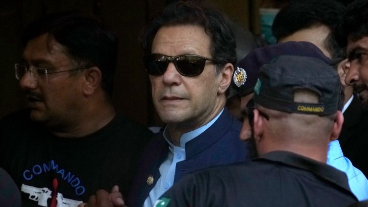 Pakistan's former Prime Minister Imran Khan, center, is escorted by security officials as he arrive to appear in a court, in Islamabad, Pakistan, Friday, May 12, 2023. A high court in Islamabad has granted Khan a two-week reprieve from arrest in a graft case and granted him bail on the charge. (AP Photo/Anjum Naveed)