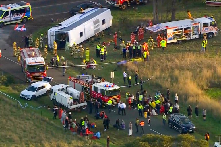 In this image made from video, rescue workers help children from a school bus that rolled onto its side on the outskirts of Melbourne, Australia, Tuesday, May 16, 2023. Seven children remain hospitalized Wednesday, May 17, with serious injuries after a truck struck a school bus Tuesday carrying as many as 45 students in southeastern Australia. (AuBC/CHANNEL 7/CHANNEL 9 via AP)