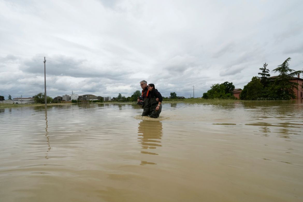A couple stuck in the middle of the flooded road of Lugo, Italy, Thursday, May 18, 2023 [Luca Bruno/AP]