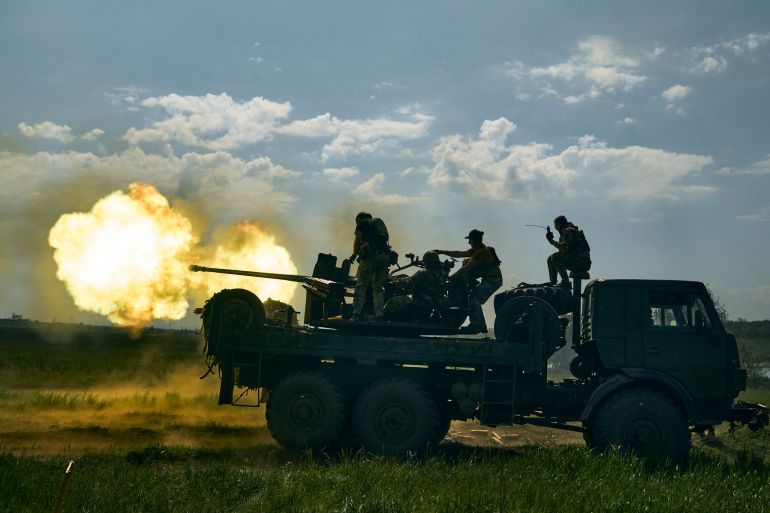 Ukrainian soldiers fire a cannon near Bakhmut,