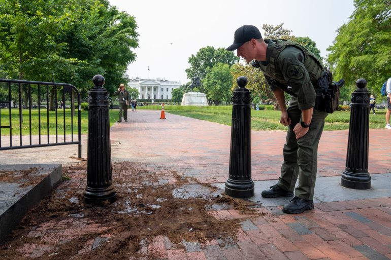 A U.S. Park Police officer inspects a security barrier for damage in Lafayette Square park near the White House