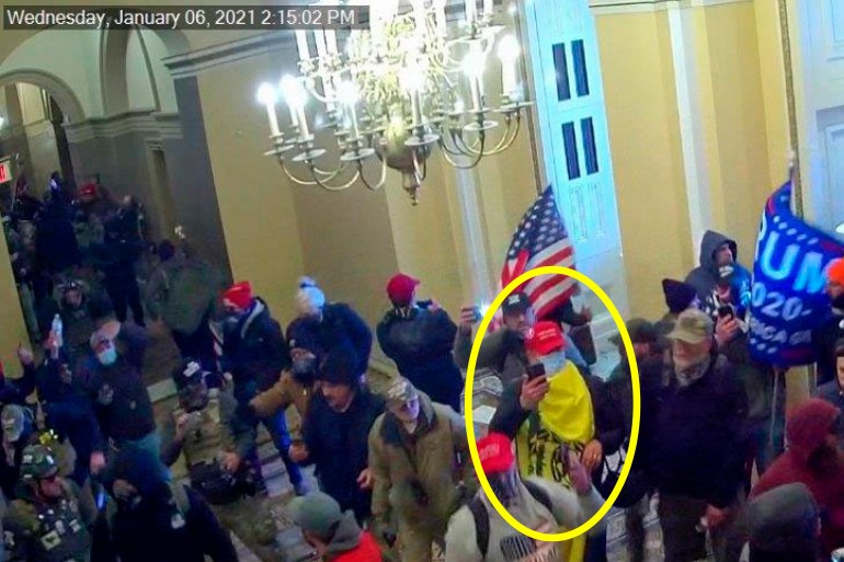 A man is circled in yellow in a video still of rioters rushing into the US Capitol