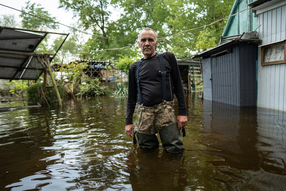 Ihor Medyunov, a local hunter stands in the courtyard of his flooded house