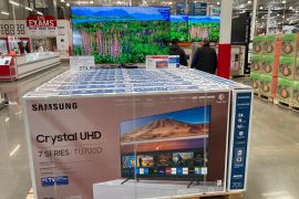 Shoppers pass by a display of big-screen televisions in a Costco warehouse in Colorado, US