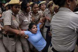 Sakshi Malik, in blue, an Indian wrestler who won a bronze medal at the 2016 Summer Olympics, is detained by the police during a protest demonstration at Jantar Mantar, an area near the Indian parliament, in New Delhi, India, Sunday, May, 28, 2023. India’s top wrestlers have been protesting for more than a month, demanding the resignation and arrest of the president of the wrestling federation for allegedly sexually harassing young athletes. (AP Photo/Altaf Qadri)