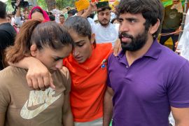 Indian wrestlers, from right, Bajrang Punia, Sangita Phogat and Vinesh Phogat talk ahead of their protest march towards the newly inaugurated parliament in New Delhi on May 28, 2023. [Shonal Ganguly/AP]