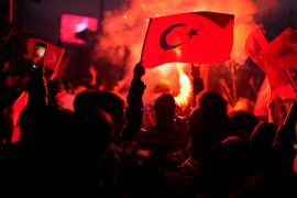 Supporters of the President Recep Tayyip Erdogan celebrate and wave a Turkish flag.