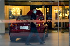 A worker walks in a Tesla showroom in Beijing, China